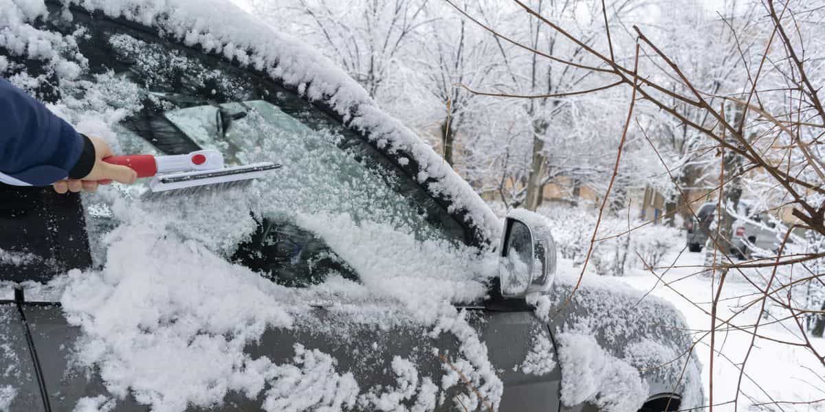 drivers hand creaning the car from snow in the royalty free image 1607617047