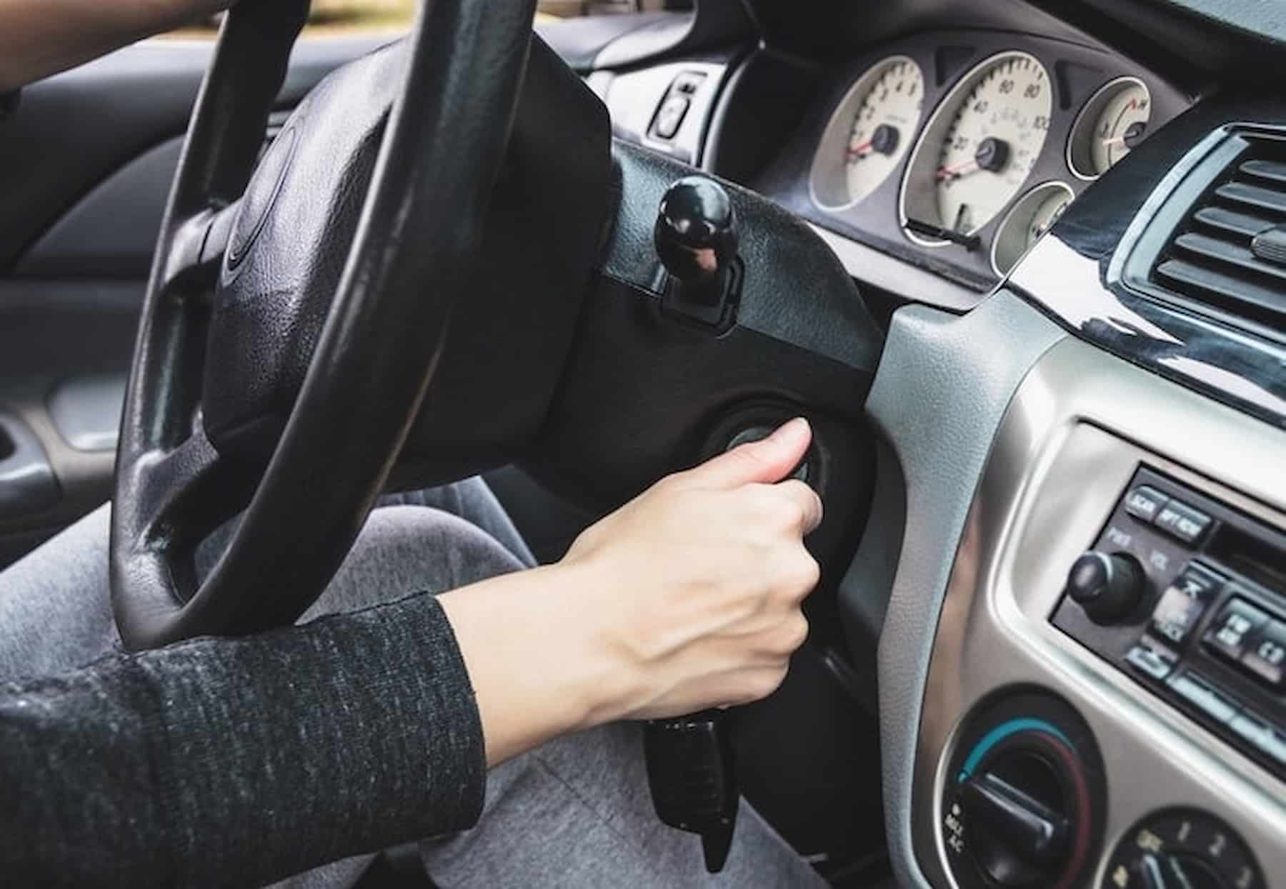 woman turning car key in ignition