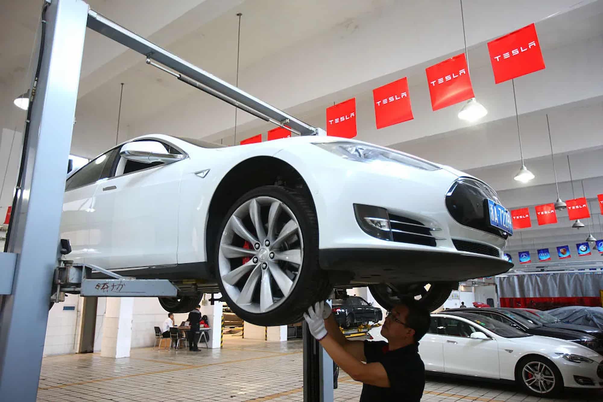 maintenance technician examines and repairs a Tesla vehicle